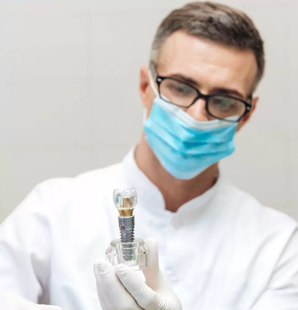 dentist with implant model being held