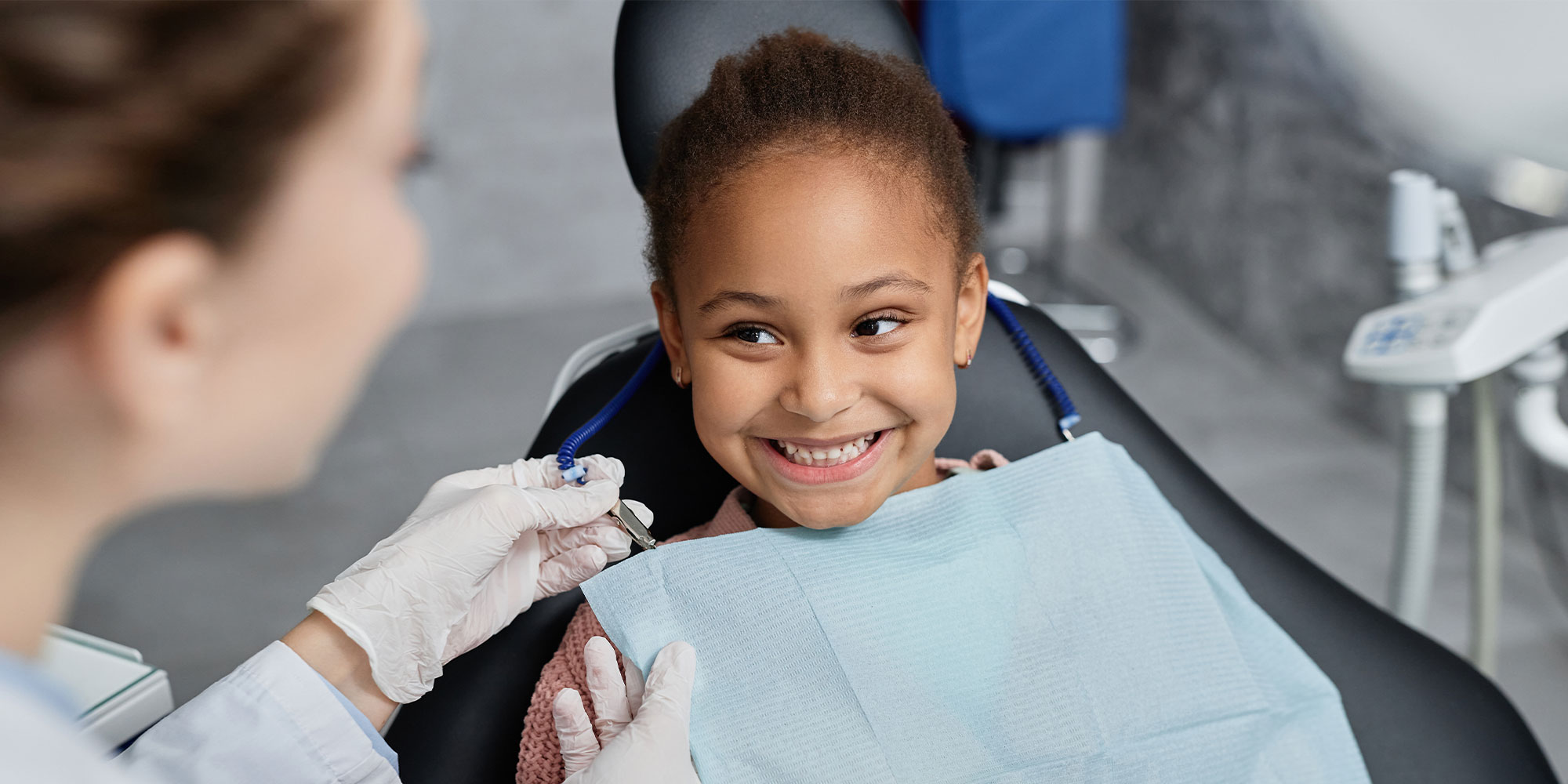 dentist with young girl in dental chair